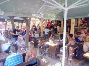 a group of people sitting at tables under an umbrella at Hostel Centrum in Mostar
