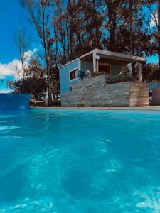 una piscina con una casa sullo sfondo di Cabañas San Jorge a Bella Vista