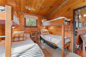 two bunk beds in a cabin with wooden walls at Hatepe Lake Taupo Retreat in Motutaiko Island