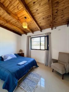 a bedroom with a blue bed and a chair and a window at Los Leños in Tafí del Valle +46 photos
