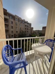 two chairs and a table on a balcony at Evoke suites apartment in central madinaty 2 bedroom in Madinaty