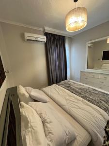a bedroom with a large bed and a mirror at Evoke suites apartment in central madinaty 2 bedroom in Madinaty