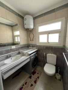 a bathroom with a sink and a washing machine at Evoke suites apartment in central madinaty 2 bedroom in Madinaty +5 photos
