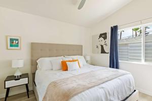 a white bedroom with a large bed and a window at Experience Modern Luxury at Desert Hideaway in Palm Springs +23 photos