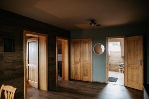a living room with wooden doors and a hallway at eM Apartments Javorník in Vacov