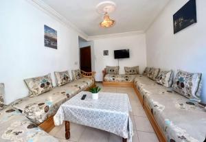 Una sala de estar con sofás y una mesa. en Mamoun allawii, en Asilah
