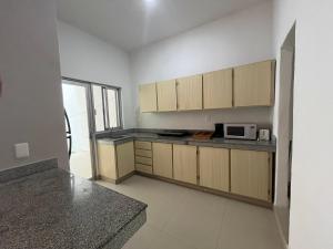 Confortable casa en Cozumel, cerca del mar #10 في كوزوميل: مطبخ مع خزائن خشبية وميكروويف +7 صور