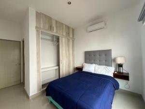 Confortable casa en Cozumel, cerca del mar #10 في كوزوميل: غرفة نوم مع سرير وبطانية زرقاء
