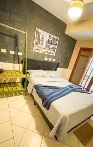 een slaapkamer met een bed in een kamer bij Casa próximo da praia do Perequê com garagem, churrasqueira e ar condicionado in Ilhabela