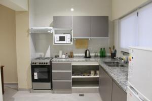 a kitchen with a stove and a microwave at Parador de Chacras Suite in Chacras de Coria