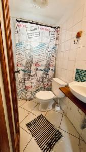 een badkamer met toilet en douchegordijn bij Casa próximo da praia do Perequê com garagem, churrasqueira e ar condicionado in Ilhabela
