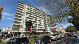 a large white building with cars parked in front of it at Edificio Stepke in Temuco