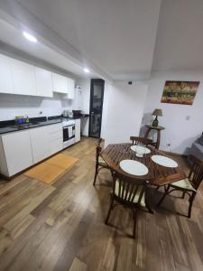 a living room with a table and chairs and a kitchen at Dpto Arroyito in Rosario