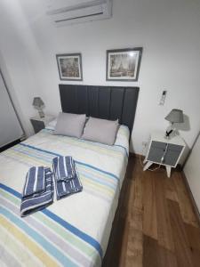 a bedroom with a bed with two towels on it at Dpto Arroyito in Rosario