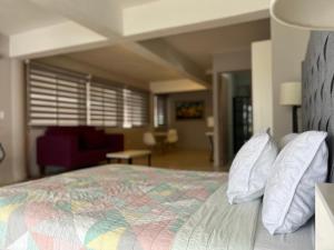una camera da letto con un letto grande con cuscini bianchi di Estudio en Cozumel con vista al mar A1 a Cozumel Altre 2 foto