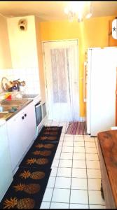 a kitchen with a refrigerator and a tile floor at 69Room69 in Lyon