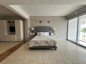 una grande camera da letto con un letto e una grande finestra di Estudio en Cozumel con vista al mar A1 a Cozumel