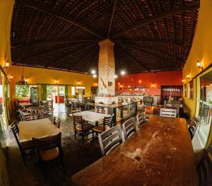 a restaurant with tables and chairs and a bar at Pousada Hygge in Bonito