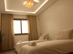 a bedroom with two beds and a window at Tamraght Surf House in Tamraght Ouzdar +19 photos