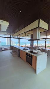 a large kitchen with a counter top and some windows at Elegância e conforto a passos da Beira-mar in Fortaleza