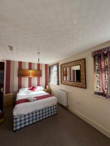 ein Schlafzimmer mit zwei Betten und einem Spiegel an der Wand in der Unterkunft VERNON Hotel in Blackpool
