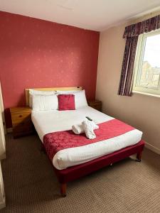 ein Schlafzimmer mit einem Bett, auf dem ein Stofftier liegt in der Unterkunft VERNON Hotel in Blackpool
