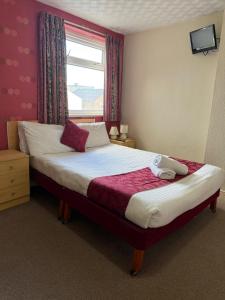 ein Schlafzimmer mit einem großen Bett und einem Fenster in der Unterkunft VERNON Hotel in Blackpool