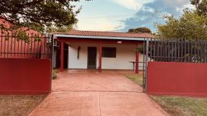 a red and white house with a gate at Casa Grande e Completa - Emite NF in Maracaju
