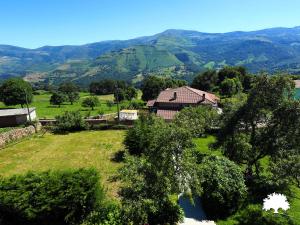 a house in a field with mountains in the background at Albergue La Incera in San Martín