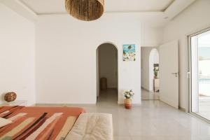 een witte slaapkamer met een bed en een groot raam bij Villa Dar Salama, 3 Chambres, Plage à 5 minutes in Midoun +6 foto's