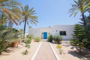 een wit huis met een blauwe deur en palmbomen bij Villa Dar Salama, 3 Chambres, Plage à 5 minutes in Midoun