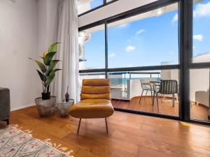a living room with a chair and a table at Beachfront Sky Loft in Herzliya B