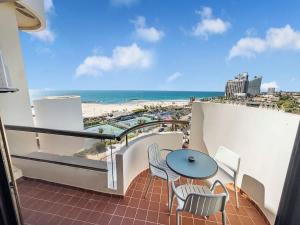 Herzliya PituahにあるBeachfront Sky Loftのビーチの景色を望むバルコニー(テーブル、椅子付)