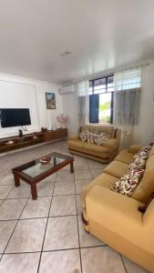 a living room with two couches and a coffee table at Cantinho do Litoral Salvador in Salvador