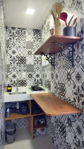 una cocina con fregadero y una pared con azulejos en Apartamentos da Gaby, en Morro de São Paulo