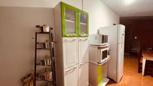 a kitchen with a refrigerator with a microwave on it at Casa Grande e Completa - Emite NF in Maracaju