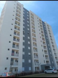 a large white building with cars parked in front of it at Apartamento Solar dos Pampas in Guaíba