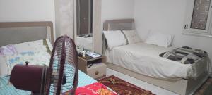 ein kleines Schlafzimmer mit einem Bett und einem Spiegel in der Unterkunft الهرم in Kairo
