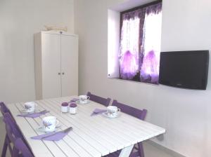 ブドーニにあるBudoni Mareの白いテーブル(椅子付)、壁掛けテレビ