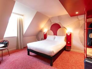 a bedroom with a large white bed and a chair at Ibis Styles Strasbourg Centre République in Strasbourg