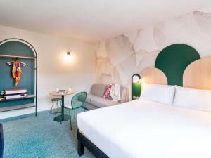 a hotel room with a bed and a couch and a table at Ibis Styles Strasbourg Centre République in Strasbourg