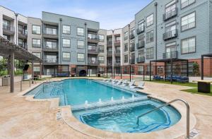 an outdoor swimming pool in front of a building at Luxury Skyline Escape, FIFA World Cup, Sauna, King Bed, DT View in Dallas
