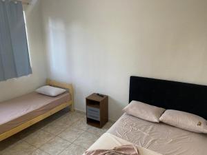 a bedroom with two beds and a night stand at Mega Hotel in Cascavel