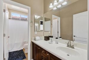 a bathroom with a sink and a toilet and a mirror at Entire Home Avondale 4Bedroom 3Bathroom in Avondale +42 photos