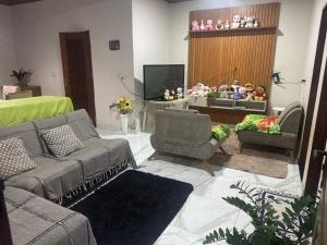 un soggiorno con divano, sedie e TV di casa paraíso a Marituba