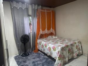 una camera con letto e ventilatore accanto a una finestra di casa paraíso a Marituba