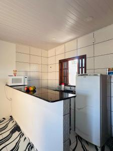 a kitchen with a counter top and a refrigerator at Casa Sol & Mar in Arraial do Cabo