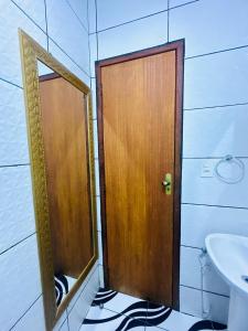 a wooden door in a bathroom with a sink at Casa Sol & Mar in Arraial do Cabo +28 photos