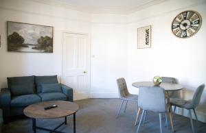 een woonkamer met een bank en een tafel bij The Channel View, 4 bedrooms, 4 beds, FREE parking, 3 minutes from the beach in Eastbourne