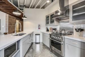 una cocina con encimeras blancas y electrodomésticos de acero inoxidable en Luxury Two Bedroom Penthouse, en Nueva Orleans 19 fotos más